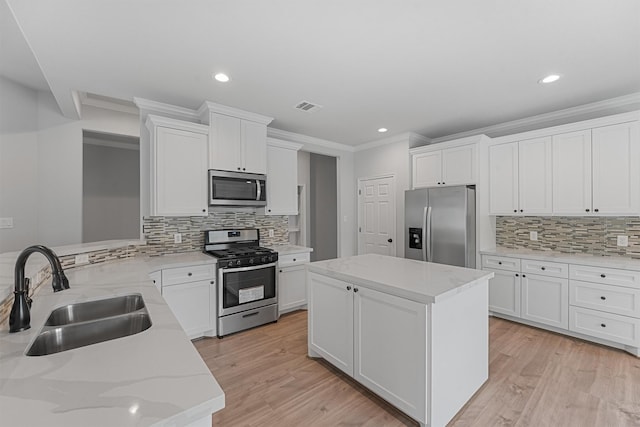 kitchen featuring a center island, sink, appliances with stainless steel finishes, white cabinetry, and kitchen peninsula