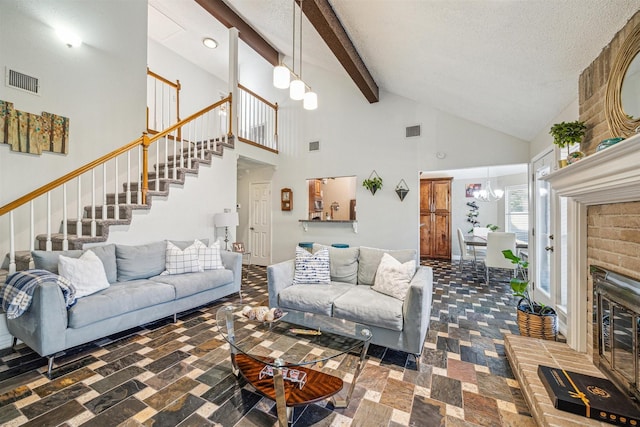 living room featuring beamed ceiling, high vaulted ceiling, a notable chandelier, a textured ceiling, and a fireplace