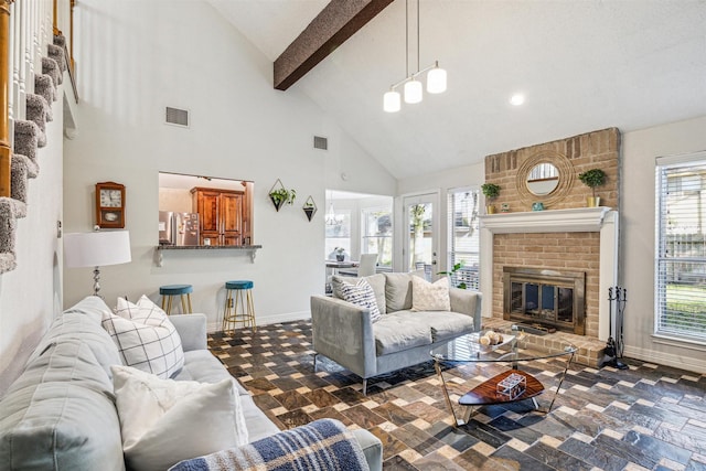 living room with beamed ceiling, a healthy amount of sunlight, high vaulted ceiling, and a brick fireplace