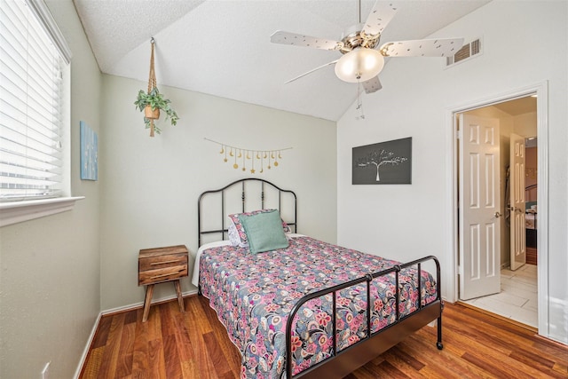 bedroom with a textured ceiling, ceiling fan, vaulted ceiling, and hardwood / wood-style flooring