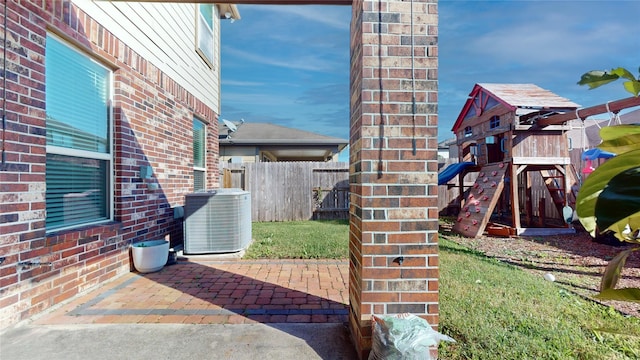 view of patio / terrace with central air condition unit and a playground