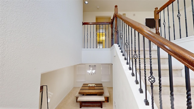 staircase with a notable chandelier