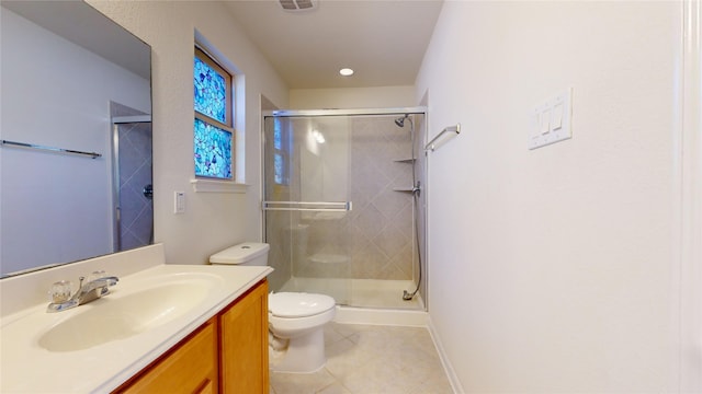 bathroom with tile patterned flooring, vanity, toilet, and a shower with door