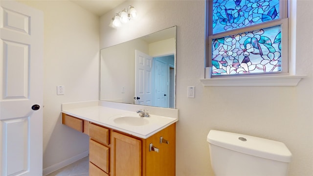 bathroom with tile patterned flooring, vanity, and toilet