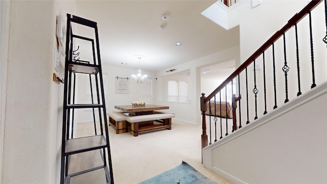 stairs with carpet floors and an inviting chandelier