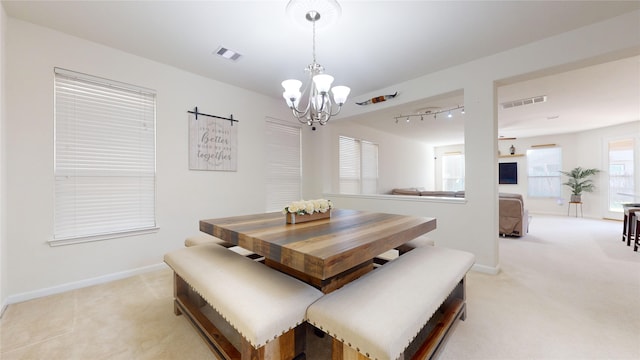 dining room featuring light colored carpet and an inviting chandelier