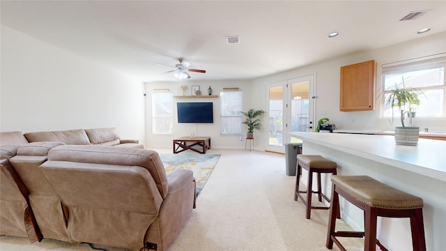 living room with ceiling fan, light carpet, and french doors