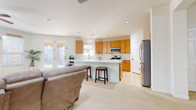 living room featuring ceiling fan, light colored carpet, and sink