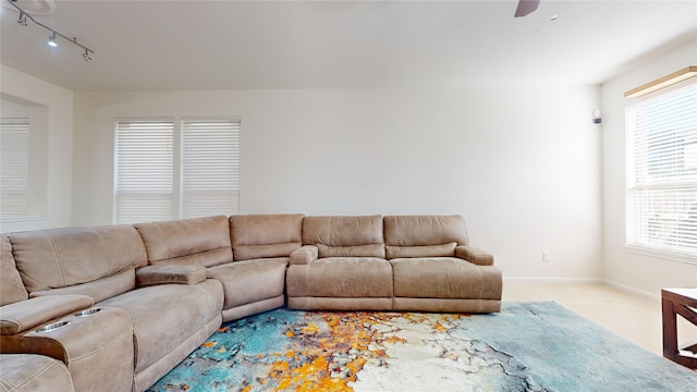 carpeted living room with ceiling fan and rail lighting