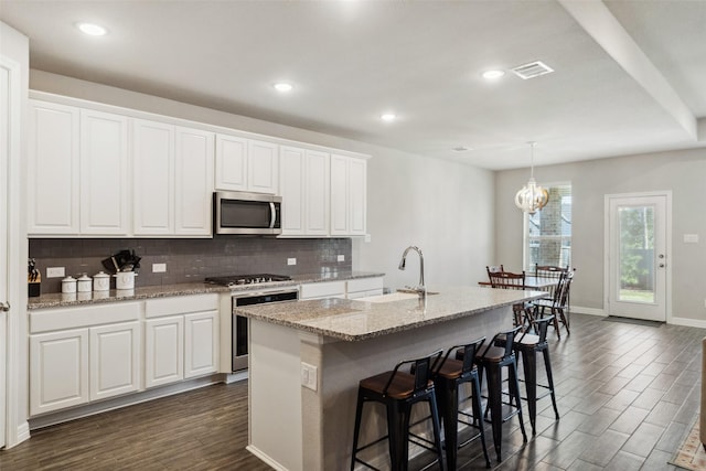 kitchen featuring white cabinetry, a kitchen island with sink, sink, and stainless steel appliances