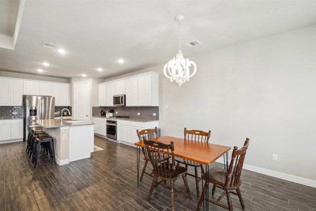 dining area featuring a chandelier and sink