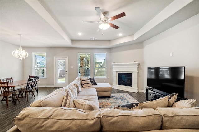 living room featuring dark hardwood / wood-style floors, a raised ceiling, and plenty of natural light