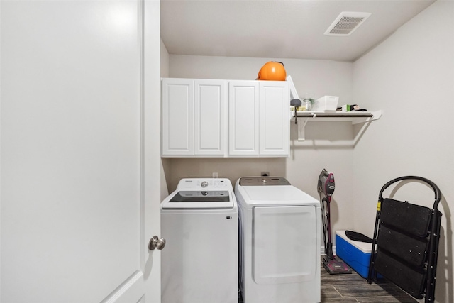 laundry room with dark hardwood / wood-style floors, cabinets, and independent washer and dryer