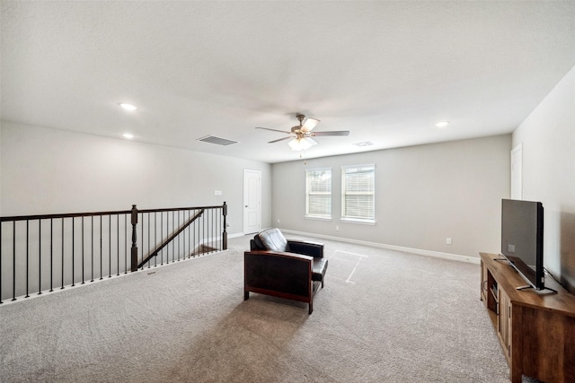 sitting room with ceiling fan and light colored carpet