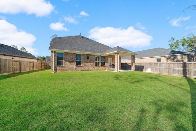 rear view of house featuring a yard