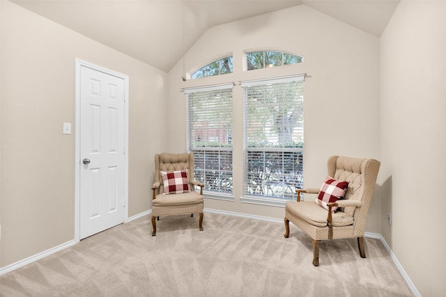 sitting room featuring light colored carpet and lofted ceiling