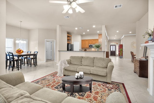 living room featuring ceiling fan with notable chandelier, plenty of natural light, and light tile patterned floors