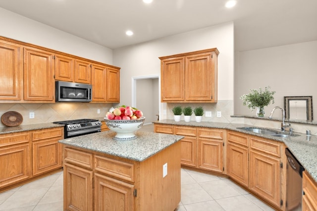 kitchen featuring appliances with stainless steel finishes, light tile patterned floors, light stone counters, and sink