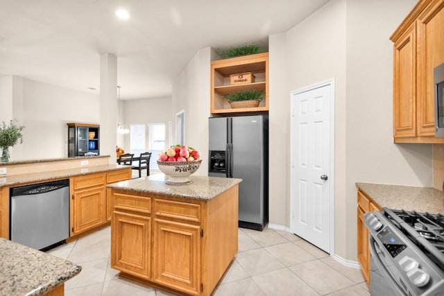 kitchen featuring a kitchen island, light tile patterned flooring, light stone countertops, and stainless steel appliances