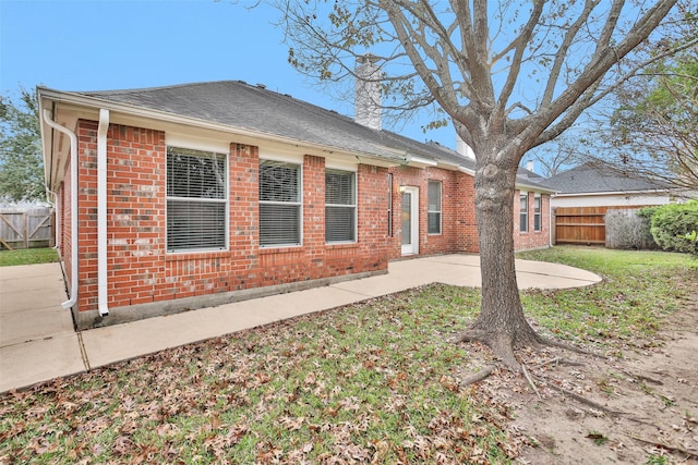 back of house featuring a lawn and a patio