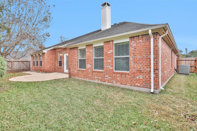 back of house featuring a yard, central AC unit, and a patio area