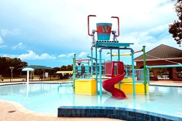 view of swimming pool featuring a playground