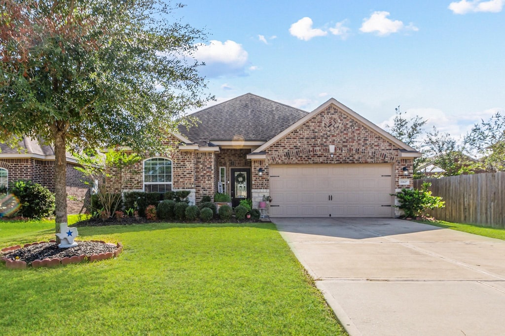 view of front of property featuring a garage and a front lawn