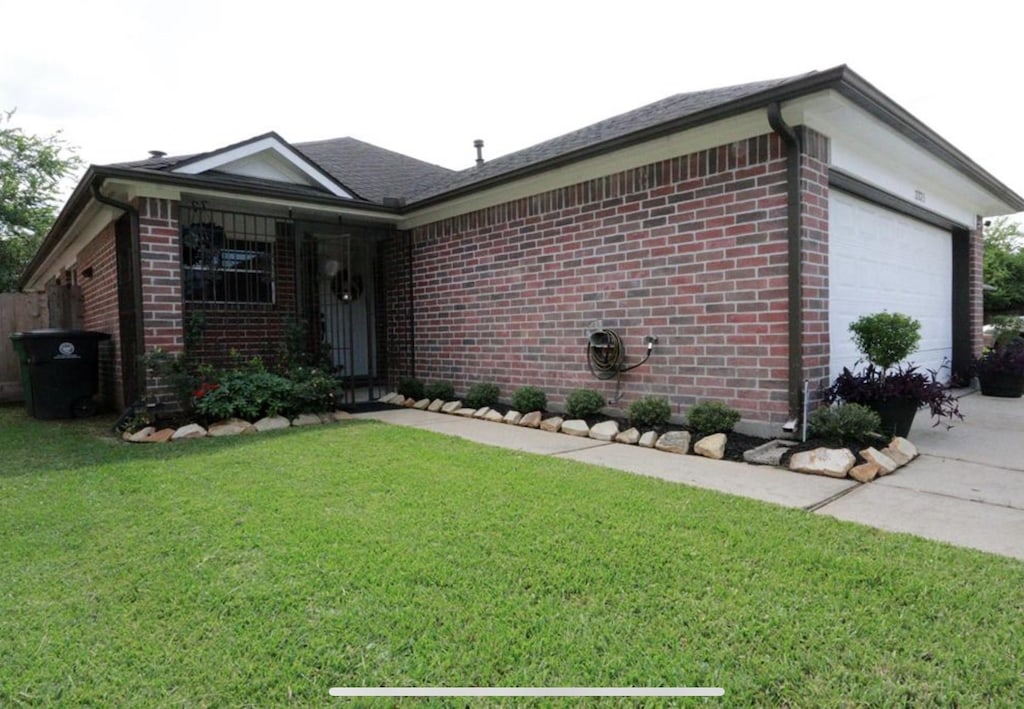 ranch-style house featuring a garage and a front yard