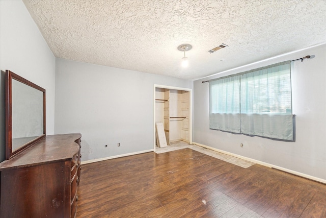 unfurnished bedroom featuring a textured ceiling and dark hardwood / wood-style floors