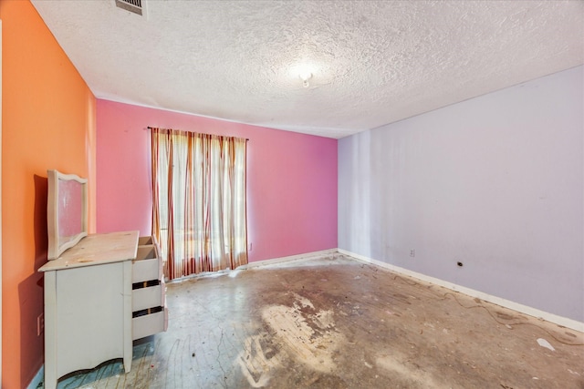 unfurnished room featuring a textured ceiling