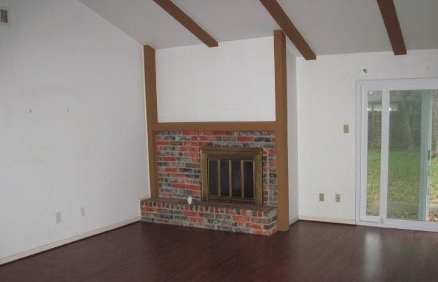 unfurnished living room with beam ceiling, dark hardwood / wood-style flooring, and a wealth of natural light