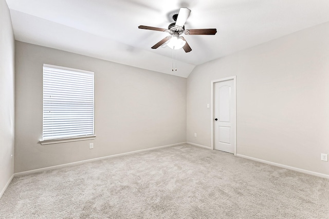 unfurnished room featuring a wealth of natural light, light carpet, and vaulted ceiling