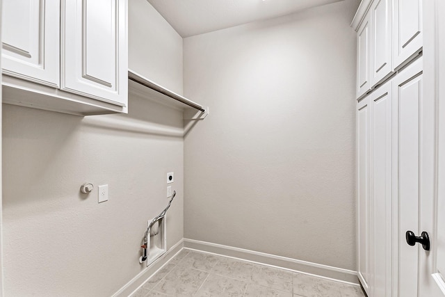 laundry area with electric dryer hookup, cabinets, gas dryer hookup, and light tile patterned floors