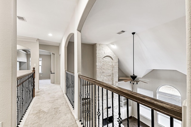 corridor with light colored carpet and lofted ceiling