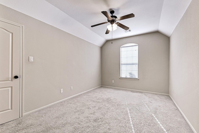 carpeted spare room with ceiling fan and lofted ceiling