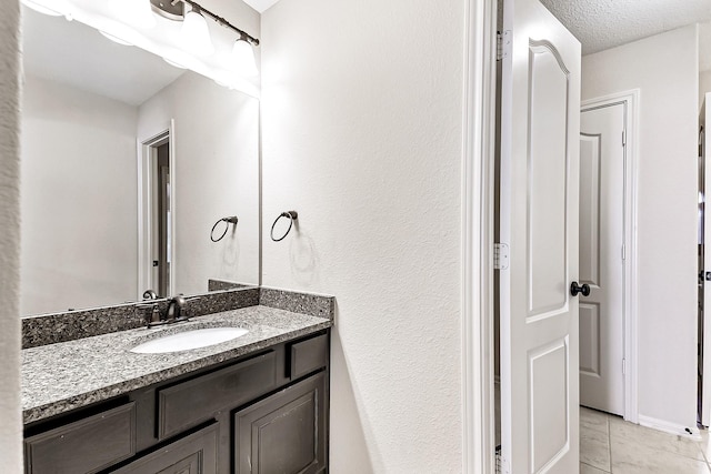 bathroom featuring a textured ceiling, vanity, and tile patterned floors