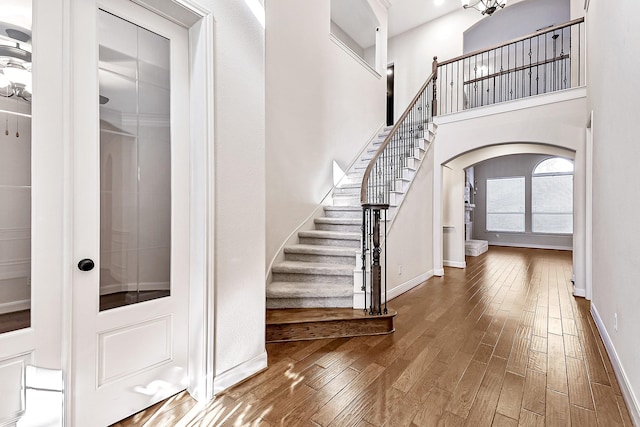 stairway featuring hardwood / wood-style floors and a towering ceiling