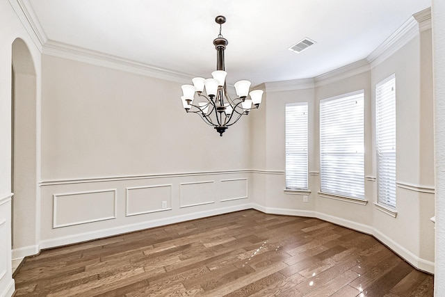 empty room with crown molding, wood-type flooring, and a notable chandelier