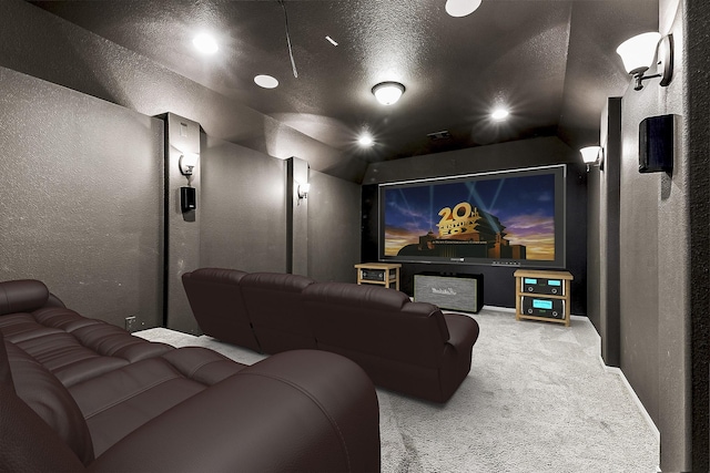 carpeted cinema room featuring a textured ceiling