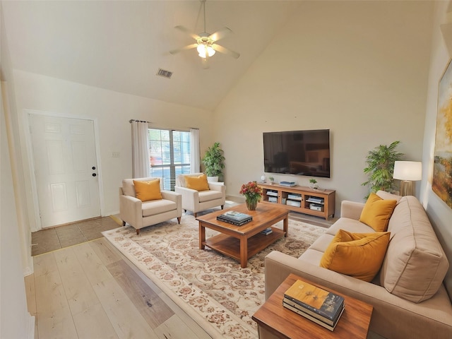 living room with ceiling fan, high vaulted ceiling, and light wood-type flooring