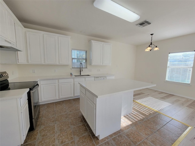 kitchen with white cabinets, pendant lighting, a kitchen island, and stainless steel range with electric cooktop