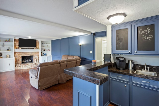 kitchen featuring blue cabinets, sink, built in features, and a textured ceiling