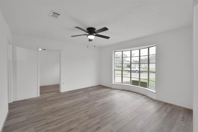 unfurnished room with ceiling fan and wood-type flooring