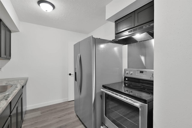 kitchen with stainless steel range with electric stovetop, light stone countertops, light wood-type flooring, and a textured ceiling