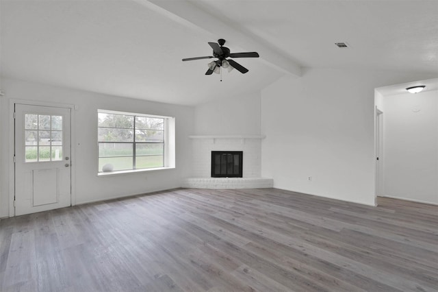 unfurnished living room with vaulted ceiling with beams, ceiling fan, a fireplace, and light wood-type flooring