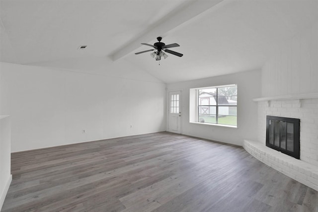 unfurnished living room with vaulted ceiling with beams, ceiling fan, wood-type flooring, and a brick fireplace