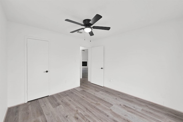 unfurnished bedroom with a closet, light hardwood / wood-style flooring, and ceiling fan