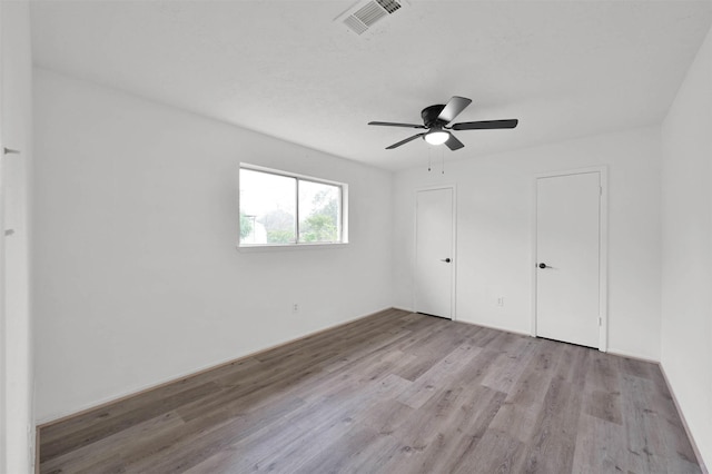 unfurnished bedroom with ceiling fan and light wood-type flooring