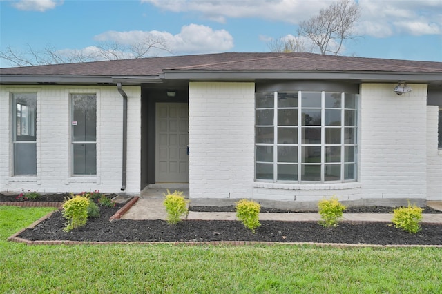 entrance to property with a lawn