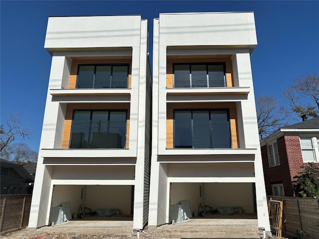 view of front of property featuring an attached garage, a balcony, and stucco siding